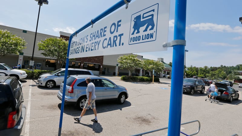 Shoppers walk in the parking lot at a Food Lion grocery store in Richmond, Va., Wednesday,...