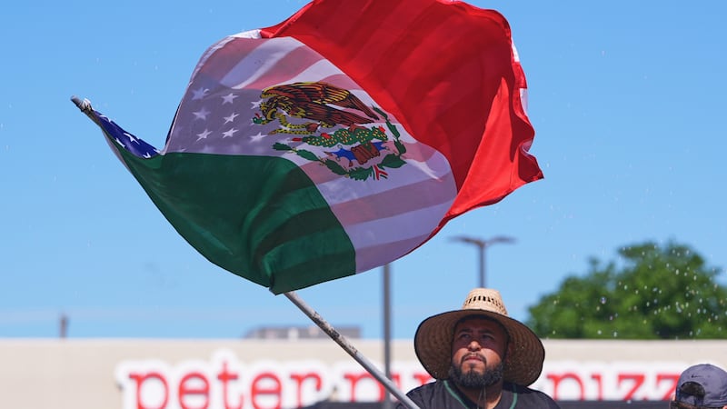 A float rider waves a U.S.-Mexico flag during a Cinco de Mayo parade in the Oak Cliff section...