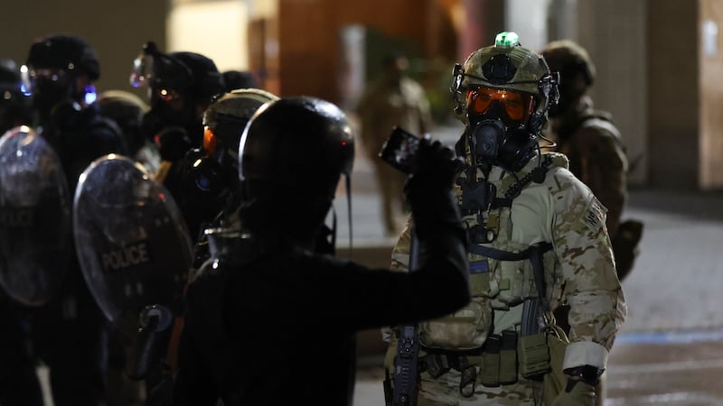 People protest outside a U.S. Immigration and Customs Enforcement facility as federal agents...