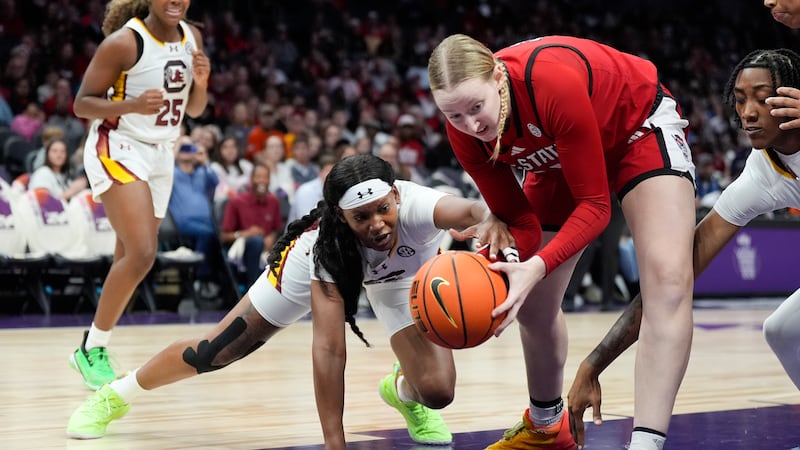 South Carolina forward Sania Feagin, left, vies for the ball with NC State forward Maddie Cox...